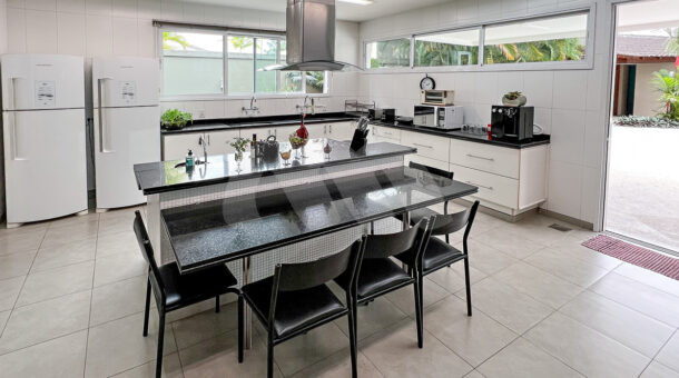 Imagem da cozinha com vista da mesa central do imóvel à venda na imobiliaria Muller Imóveis RJ.