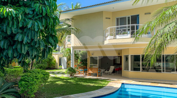 Imagem frontal da casa com vista da piscina do imóvel à venda na imobiliaria Muller Imóveis RJ.