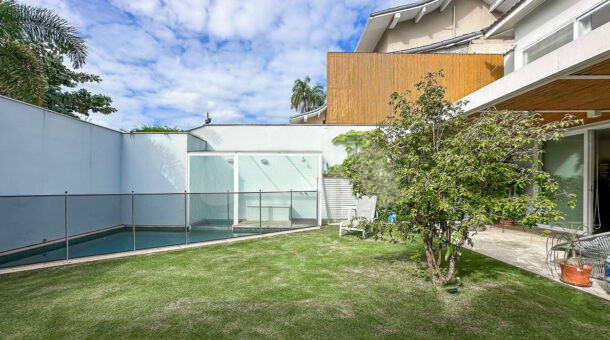 Imagem da entrada com gramado e piscina da casa duplex no Lagoa Mar Norte à venda na Barra da Tijuca
