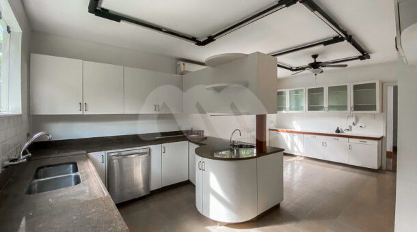 Imagem da cozinha com ampla bancada da casa triplex no Pedra de Itaúna à venda na Barra da Tijuca
