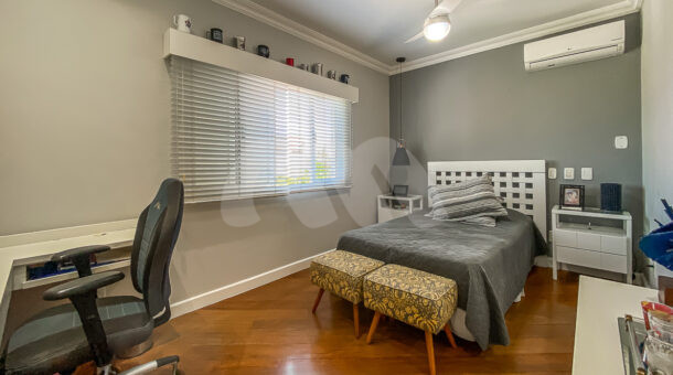Imagem do quarto com vista da cama de solteiro da mansão moderna à venda na Muller Imóveis RJ.
