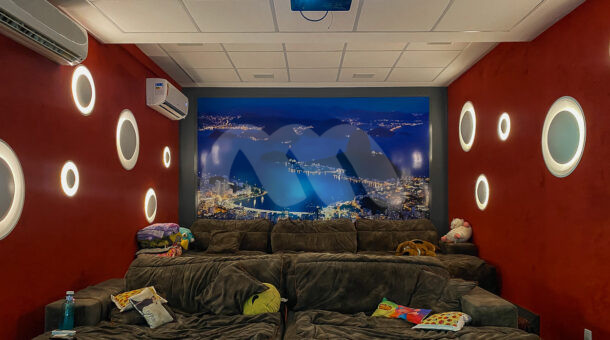 Imagem de sala de cinema com dis sofás e projetor