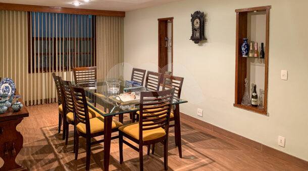 Imagem de sala de jantar com prateleira embutida na parede, mesa de jantar de madeira e vidro e aparador em casa duplex a venda no condominio amaba