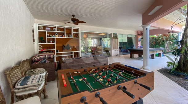 Imagem de varanda com mesa de jogos e sofá lounge em casa triplex a venda