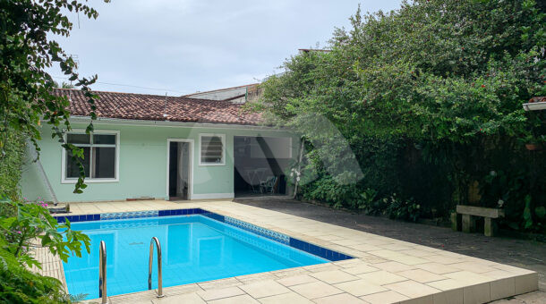 Imagem de casa com piscina e ampla arborização ao redor