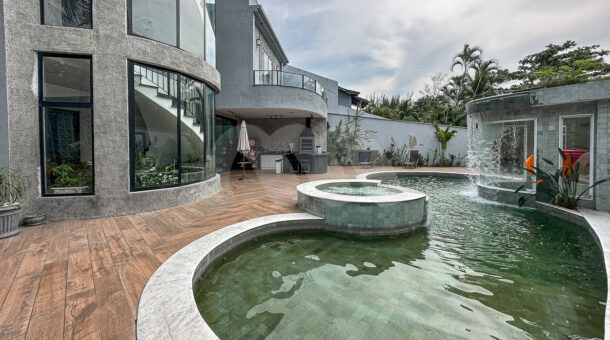 Imagem de ampla piscina com hidromassagem e cascata em casa de 4 andares