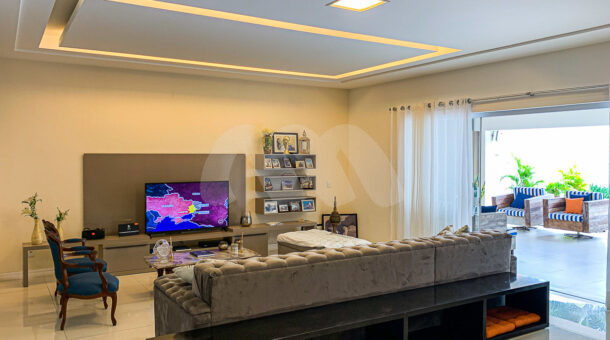Imagem de sala de estar com conceito aberto e teto em led em casa triplex à venda na Muller Imóveis RJ