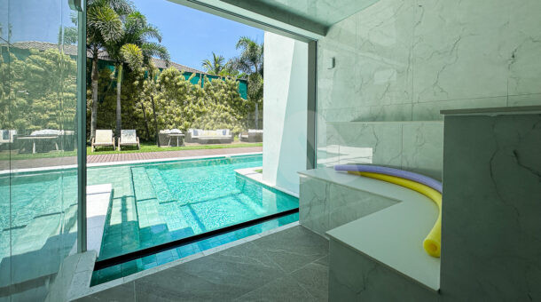 Imagem da sauna com vista da piscina do imóvel de luxo à venda.