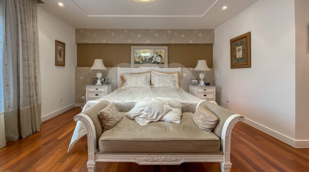 Imagem de ampla suite com cama de casal e moveis vintages em casa triplex de alkto padrao