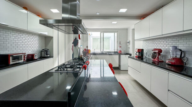Imagem da cozinha com ampla bancada da casa duplex no Lagoa Mart Norte à venda na Barra da Tijuca