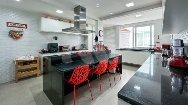 Imagem da cozinha com ampla bancada da casa duplex no Lagoa Mart Norte à venda na Barra da Tijuca