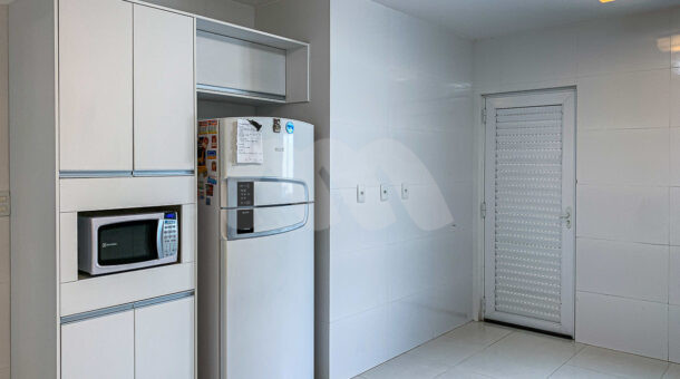 Imagem de armário planejado com geladeira e microondas em casa triplex a venda em condomínio de alto padrão