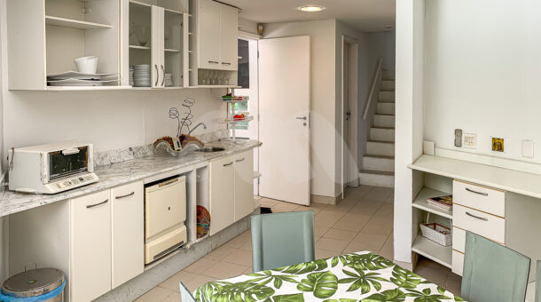 Imagem lateral da cozinha da casa à venda em condomínio de alto padrão.