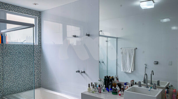 Imagem de banheiro com hidromassaem, bancada com cuba branca e chuveiro da casa moderna à venda na Muller Imoveis RJ