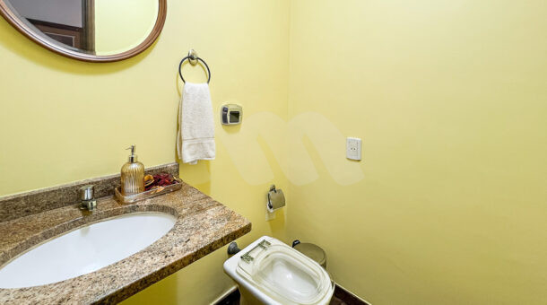 Imagem lateral do lavabo da casa à venda em condomínio de alto padrão.