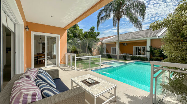 Imagem da área de lazer com varanda coberta e ampla piscina da casa à venda na Muller Imóveis RJ no Recreio