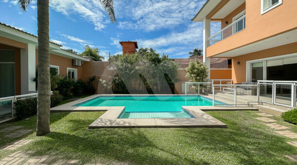 Imagem da área de lazer com piscina e gramado da casa à venda na Muller Imóveis RJ no Recreio
