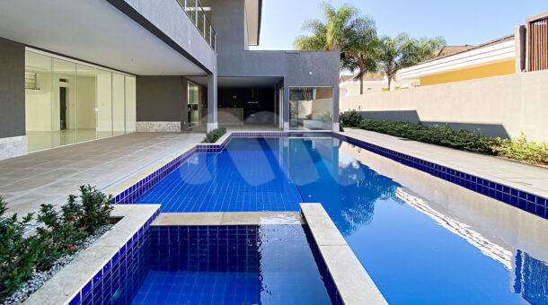 Imagm de ampla piscina com prainha e hidromassagem em casa triplex a venda na Barra