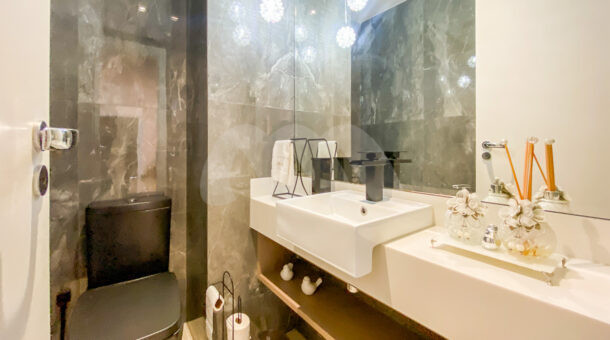Imagem de lavabo com bancada planejada e cuba em casa triplex contemporanea no Recreio