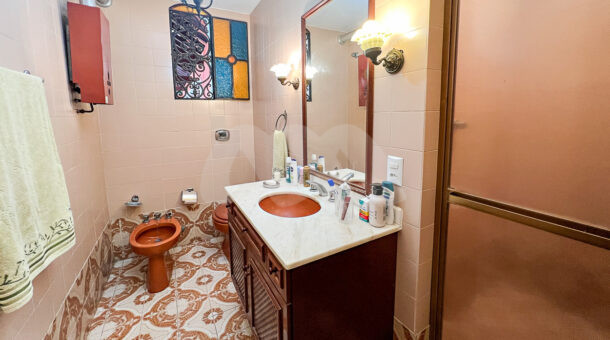 Imagem lateral do banheiro com móveis antiquario do imóvel à venda na Muller Imóveis RJ