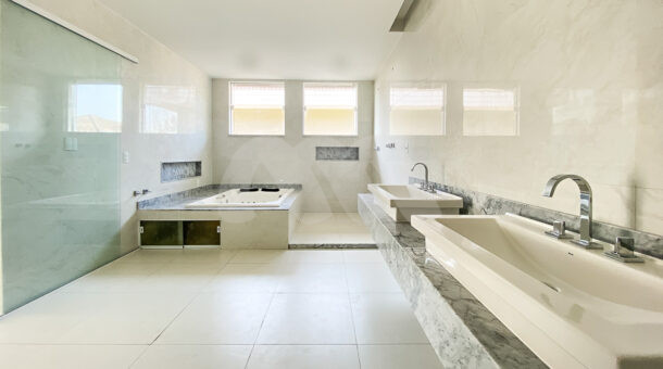 Imagem de amplo banheiro com bancada dupla e banheira de hidromassagem