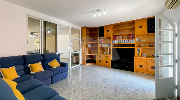Imagem da sala com móveis em madeira da casa à venda em luxoso condomínio de mansões.