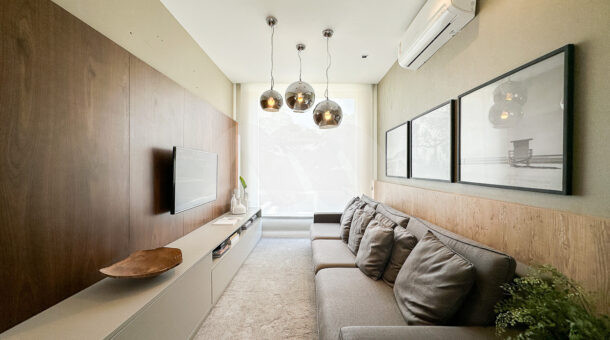 Imagem lateral da sala de Tv da mansão moderna à venda na Muller Imóveis RJ.