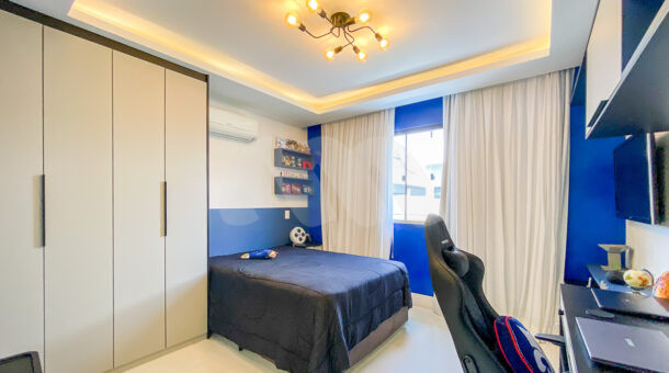 Imagem de quarto com parede azul, armário, escrivaninha planejada e cama de casal