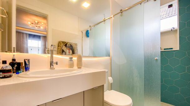 Imagem de banheiro com bancada branca, espelho r box com panilhaa em moisaco de Casa contemporanea à venda no Recreio