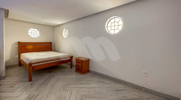Imagem de sotao com cama de casal e mesa de cabeceira de casa de 4 andares a venda