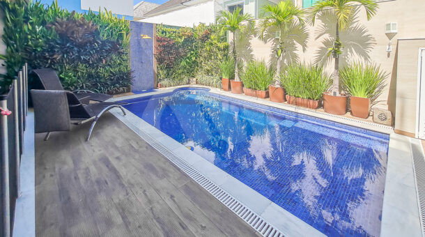 Imagem lateral da piscina da casa à venda em condomínio de alto padrão.