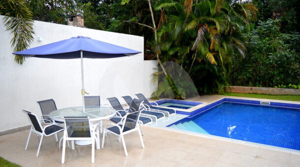 Imagem lateral da piscina da casa à venda em luxoso condomínio de mansões.