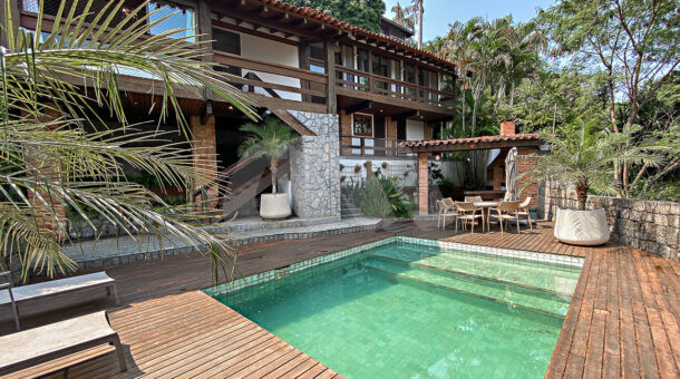 Imagem da piscina com vista do imóvel à venda em condomínio de mansões.