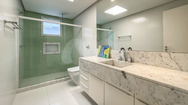 Imagem de banheiro com bancada de marmore e chuveiro com box de casa triplex a venda