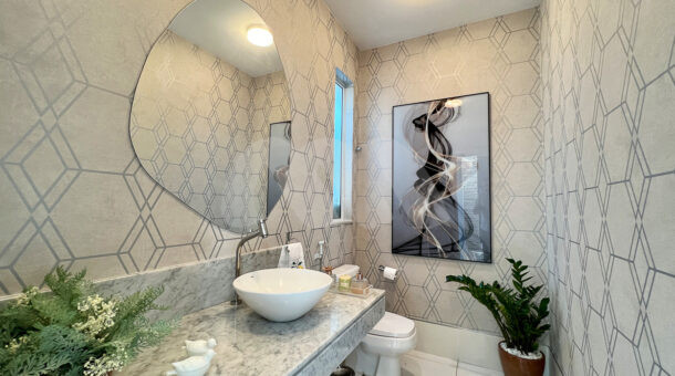 Imagem de belo lavabo com bancada, cuba e decoração da casa duplex à venda no condomínio quintas do rio na barra da tijuca