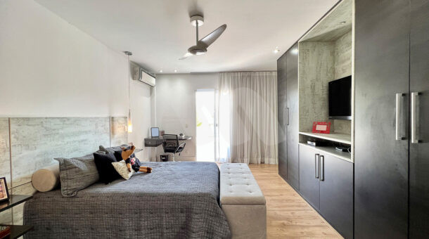 Imagem de suite com cama de casal e moveis planejados da casa duplex à venda no condomínio quintas do rio na barra da tijuca