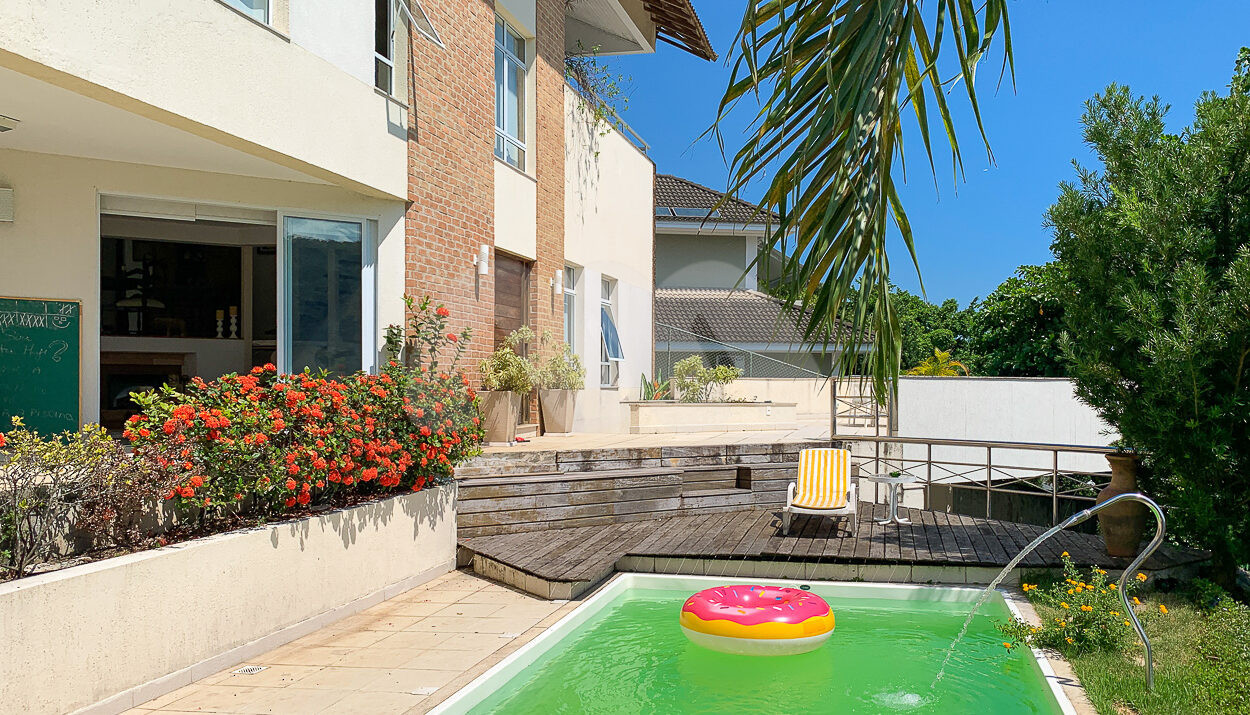 Imagem de area de piscina com deck de madeira e jardim em casa duplex a venda