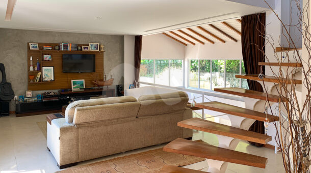 Imagem de sala de tv com sofá e rack com painel em casa duplex a venda