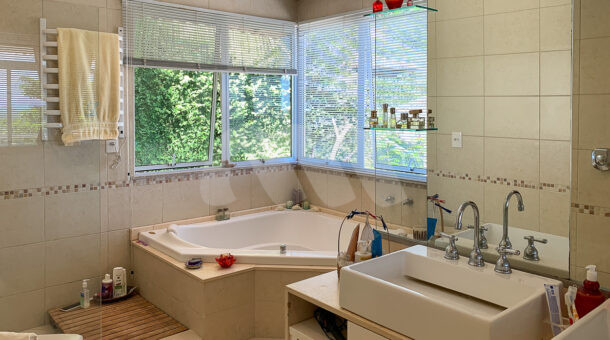 Imagem de banheiro com hidromassagem, bancada com duas cubas e box em casa duplex a venda