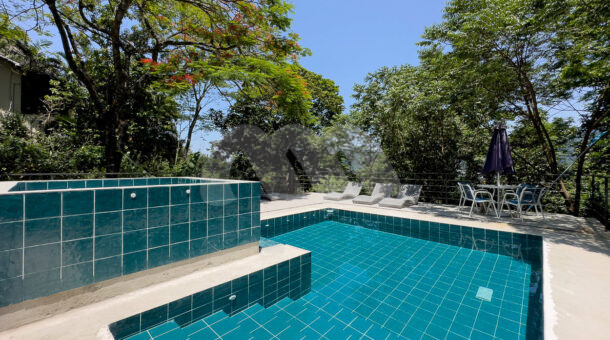 Imagem lateral da piscina da casa à venda em prestigioso condomínio.
