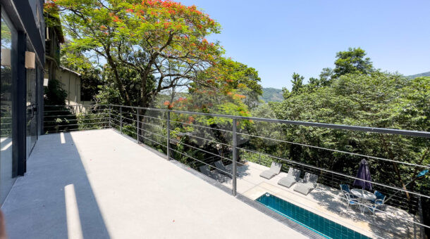 Imagem lateral da varanda com vista do paisagismo do belissimo imóvel na Barra.