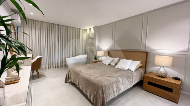 Imagem de suite decorada em tom cinza e madeira da Casa Triplex à venda no Riviera del Sol no Recreio dos Bandeirantes