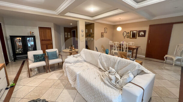 Imagem lateral da sala com sofá da casa à venda em condomínio de alto padrão.