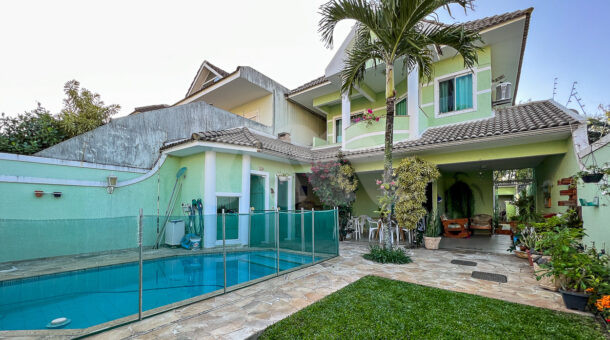 Imagem frontal da piscina da mansão moderna à venda na Muller Imóveis RJ.
