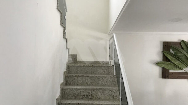 Imagem da escada da casa à venda em prestigioso condomínio.