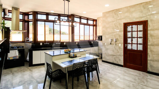Imagem de ampla cozinha com porcelanato e janelas em parede de casa triplex a venda