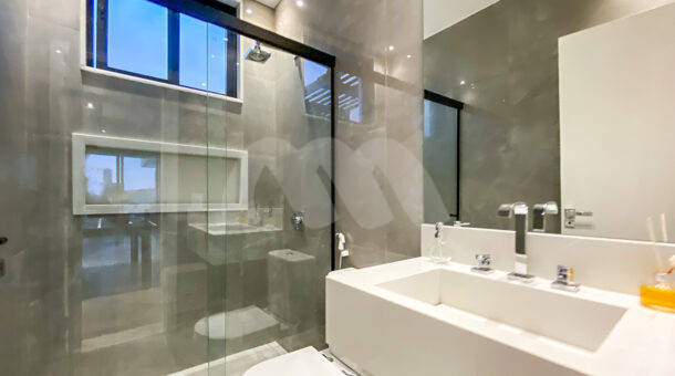 Imagem lateral do banheiro suite cinza do imóvel à venda na Muller Imóveis RJ
