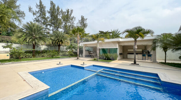 imagem da área externa com ampla piscina da casa triplex com 1100m² de terreno à venda na Barra da Tijuca