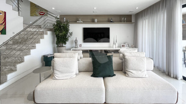 Imagem de sala de tv com sofá branco da Casa Triplex à venda no Parque das Palmeiras no Recreio dos Bandeirantes