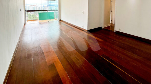Imagem da sala com piso de madeira do apartamento reformado à venda no Novo Leblon